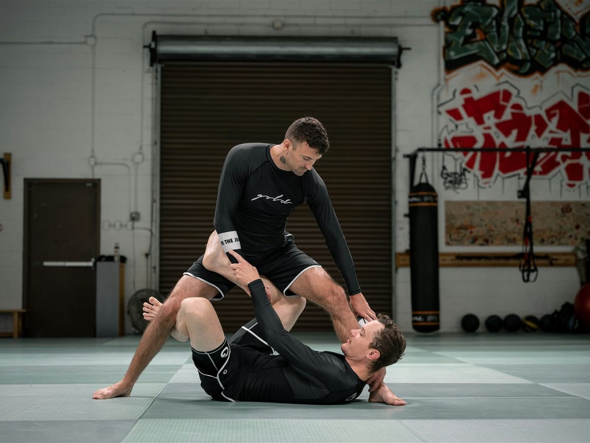 Two grapplers training No-Gi Jiu Jitsu, working from open guard on the mat