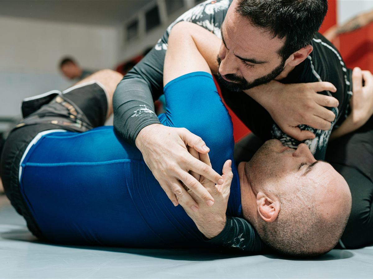Two grapplers training on the mat, working for control and a submission
